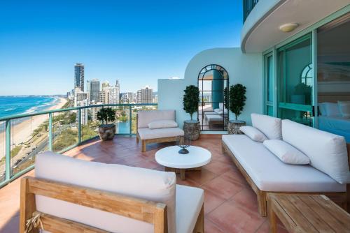 a balcony with white furniture and a view of the ocean at The Waterford on Main Beach in Gold Coast