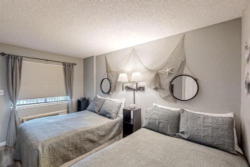 a bedroom with two beds and a mirror on the wall at Bluewater Resort 816 in Myrtle Beach