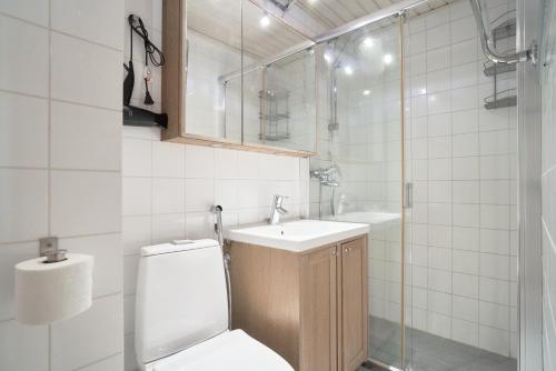 La salle de bains est pourvue de toilettes, d'un lavabo et d'une douche. dans l'établissement Norden Homes Peaceful & Central Apt. Free Parking, à Turku