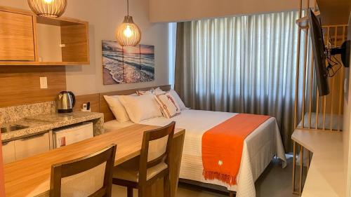 a bedroom with a bed and a table with chairs at Costa Solar Lagoa in Florianópolis