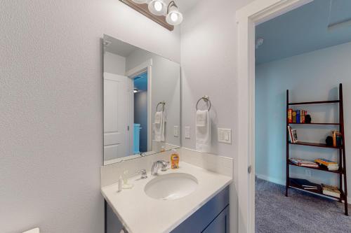 a bathroom with a sink and a mirror at Pelican and the Raven in Rockaway Beach