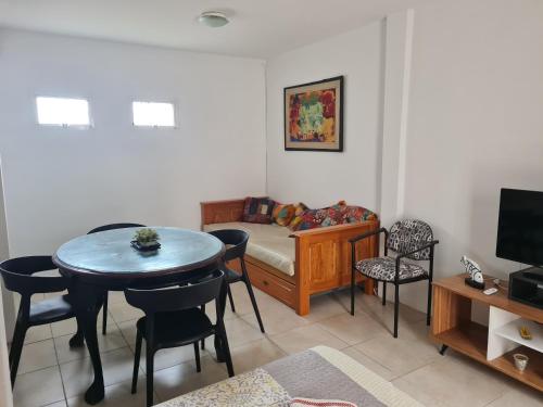 sala de estar con mesa y cama en Rio y arena en Paraná