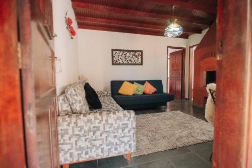 a living room with a blue couch and a rug at Chalé das Carpas in Penedo