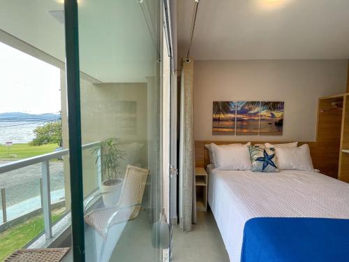 a bedroom with a bed and a view of the ocean at Costa Solar Lagoa in Florianópolis