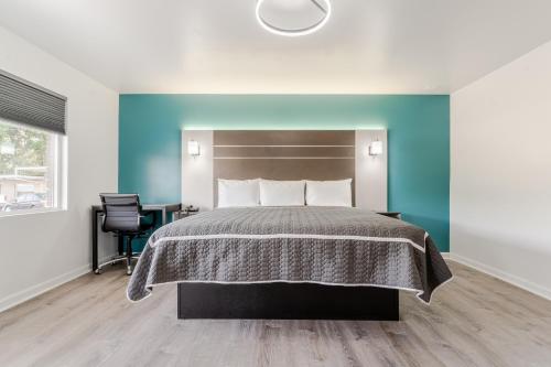a bedroom with a bed and a blue wall at Blue Beach Motel Providence North Kingstown in North Kingstown