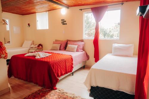 a bedroom with two beds and a window at Chalé das Carpas in Penedo
