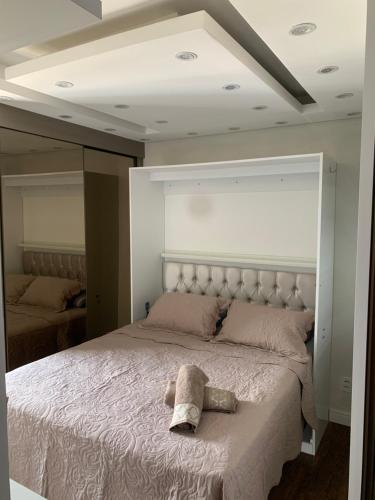 un dormitorio con una cama con un animal de peluche en Flat Master com Hidromassagem privativa e piscina 500mts praia, en São Vicente