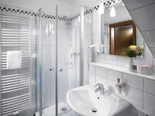 biała łazienka z umywalką i prysznicem w obiekcie Landgasthof Hoffmann GbR w mieście Arnsberg