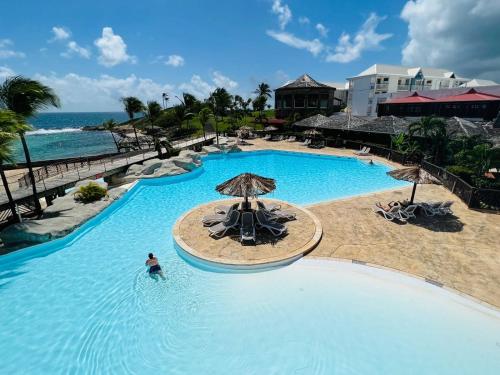 a person in the water at a swimming pool at a resort at Ti Coco Location - Manganao Saint-François avec Citerne Tampon Automatique in Saint-François