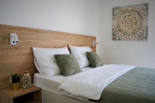 sypialnia z łóżkiem z białą pościelą i poduszkami w obiekcie Villa Nana Pag w mieście Pag
