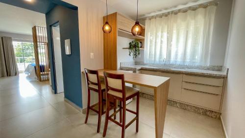 a kitchen with a wooden table and two chairs at Costa Solar Lagoa in Florianópolis