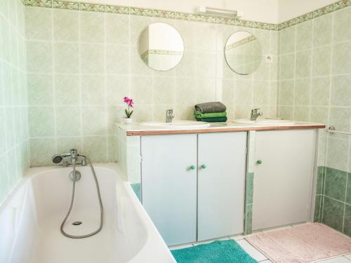 een badkamer met 2 wastafels en een bad bij Maison Girou Haut in Montcabrier