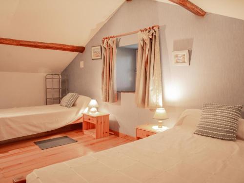 een slaapkamer met 2 bedden en een raam erin bij Maison Girou Haut in Montcabrier