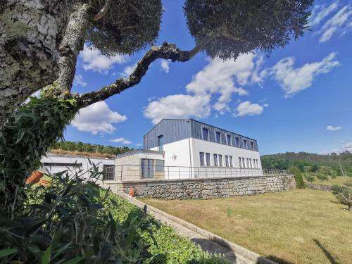 a large white building on top of a stone wall at Casa da Escola in Vouzela