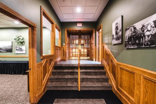 a hallway with stairs in a building with green walls at The Pollard Hotel in Red Lodge