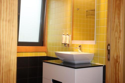 een badkamer met een wastafel en een spiegel bij Casa da Escola in Vouzela