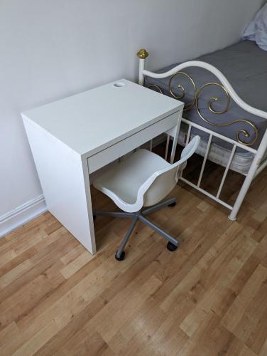 einen weißen Schreibtisch mit einem Stuhl neben einem Bett in der Unterkunft Oldham town centre rm03 in Oldham