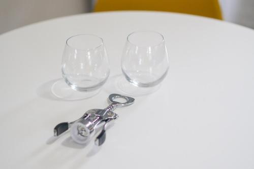 two wine glasses and a pair of scissors on a table at Retro Retreat renovated 2BR, desk, no chore list! in Kingston