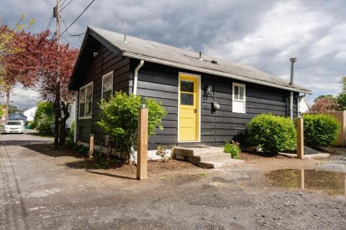 a small black house with a yellow door at Retro Retreat renovated 2BR, desk, no chore list! in Kingston