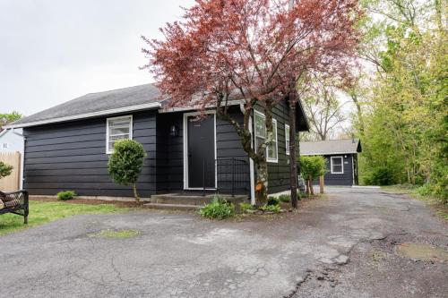 a black house with a driveway in front of it at Retro Retreat renovated 2BR, desk, no chore list! in Kingston
