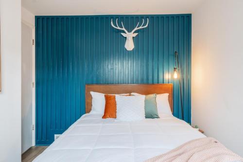 a bedroom with a bed with a blue wall at Retro Retreat renovated 2BR, desk, no chore list! in Kingston