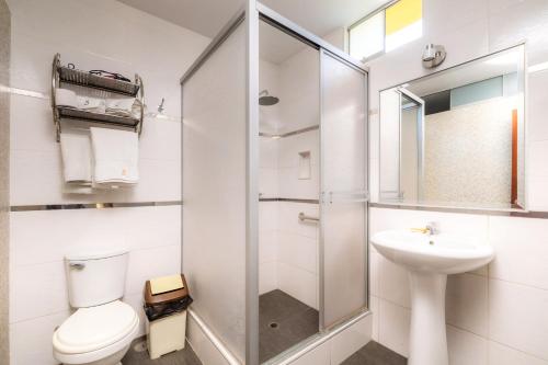 een witte badkamer met een toilet en een wastafel bij Hotel Portada Del Sol in Trujillo