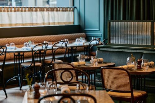 a restaurant with tables and chairs with glasses on them at Rydges Melbourne in Melbourne