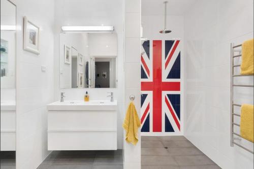 a bathroom with a sink and a flag on the wall at Azami - Charming Gilbert Cottage in Adelaide