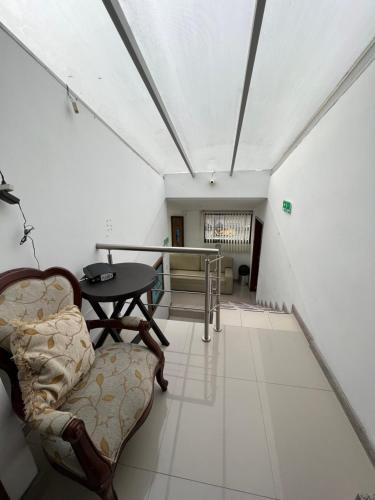 ein Wohnzimmer mit einem Tisch und einem Stuhl in der Unterkunft Hotel Tempus in Pasto