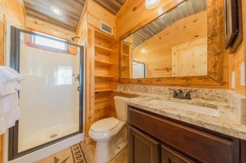 y baño con aseo, ducha y lavamanos. en D&R Rivercity RV Resort en New Braunfels