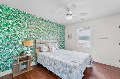 ein Schlafzimmer mit einem Bett und einer grünen Wand in der Unterkunft Just Coastin in Kill Devil Hills