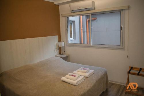 um quarto com duas toalhas numa cama com uma janela em Apart Design em Tartagal
