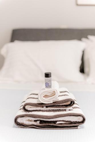 a pile of towels sitting on top of a bed at Hermes Modern Apartment in Alexandroupoli