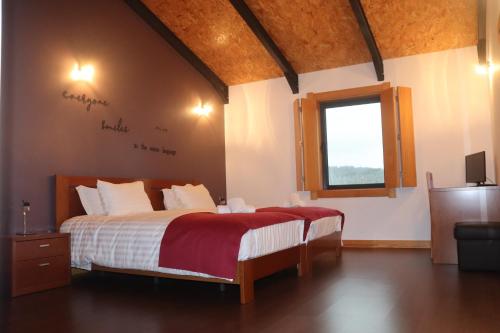 Schlafzimmer mit einem großen Bett und einem Fenster in der Unterkunft Casa da Escola in Vouzela