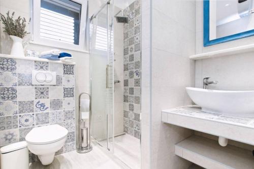 a bathroom with a shower and a toilet and a sink at Family friendly house with a swimming pool Plano, Trogir - 21403 in Prgomet