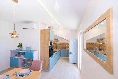 a kitchen with blue cabinets and a wooden table at Family friendly house with a swimming pool Plano, Trogir - 21403 in Prgomet