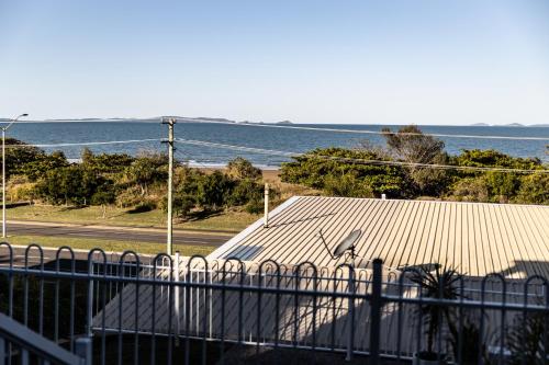 a building with a metal roof next to the ocean at Michaels by the Sea in Yeppoon