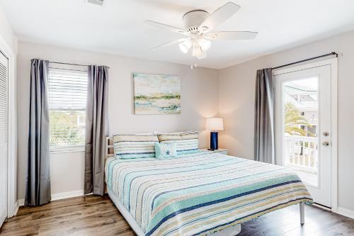 Schlafzimmer mit einem Bett und einem Deckenventilator in der Unterkunft Flood Reef Retreat - Blue Crab Cottage in Pensacola