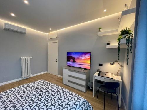 a bedroom with a desk and a flat screen tv at Luxury Downtown - Milan MF Apartments in Milan