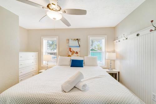 um quarto com uma cama branca e uma ventoinha de tecto em Casa Del Sol C em Bradenton Beach