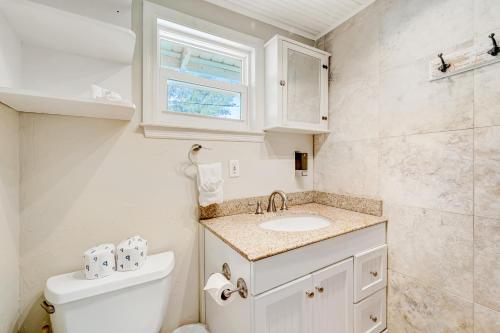 a bathroom with a toilet and a sink and a window at Casa Del Sol C in Bradenton Beach