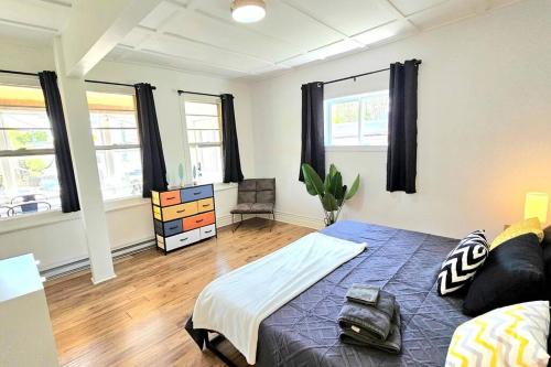 ein Schlafzimmer mit einem Bett in einem Zimmer mit Fenstern in der Unterkunft WOW - 2CH Vieux-Limoilou à proximité Vieux-QC in Québec