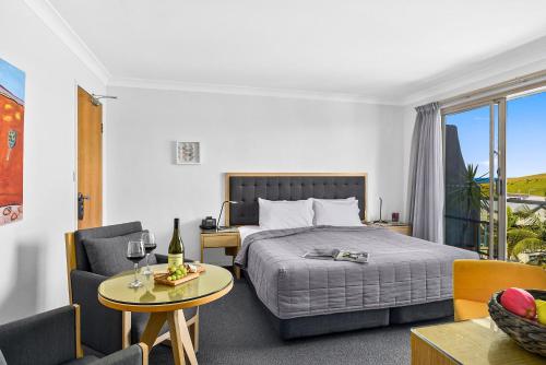 Habitación de hotel con cama, mesa y sillas en Park Ridge Retreat, en Gerringong