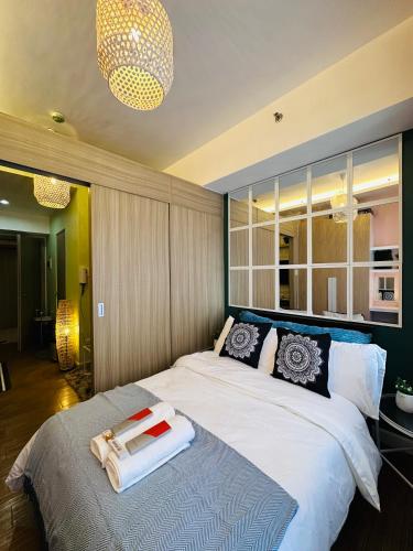 1 dormitorio con 1 cama grande y toallas. en 5th One Bedroom Condo in Upscale BGC, en Manila