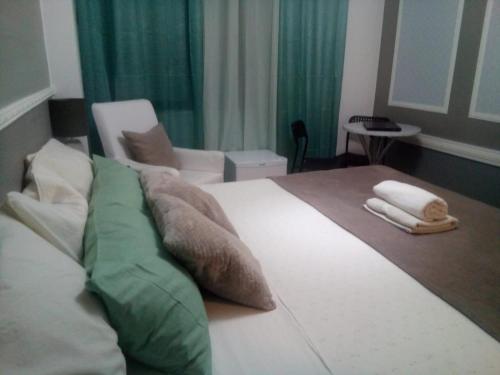 sypialnia z dużym łóżkiem z zielonymi i białymi poduszkami w obiekcie Guest House Sintra w mieście Queluz