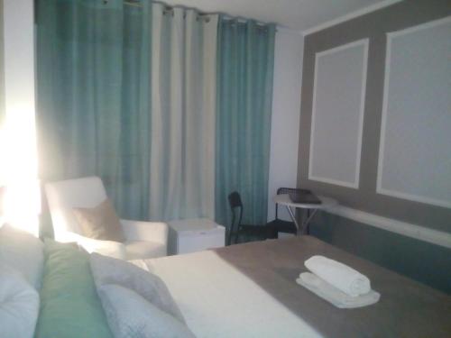 Habitación de hotel con cama y silla en Guest House Sintra, en Queluz