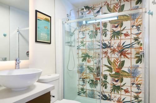 a bathroom with a shower with a toilet and a sink at MaKai Sunset Inn in Lahaina