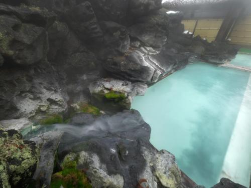 an aerial view of a blue pool of water and rocks at Ryokan Tamagoyu in Machi-niwasaka