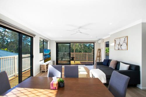 - un salon avec un canapé et une table dans l'établissement Renovated Coastal getaway with water views, à Umina