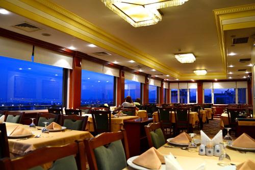 ein Restaurant mit Tischen und Stühlen und Aussicht in der Unterkunft Hotel Erden Sarayevo in Istanbul